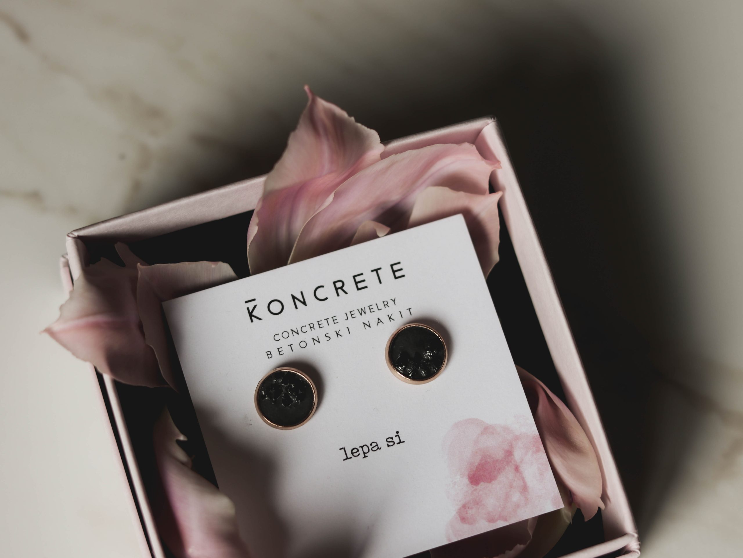 Ročno izdelani betonski uhani vsebujejo naraven kristal črni turmalin, ki ščiti tvojo energijo pred slabimi zunanjimi, je ščit, zatočišče, ko si najbolj anksiozna in varen oklep, ki te obda s samozavestjo in novo močjo! Da bodo tvoji novi najljubši uhančki na varnem pa bo poskrbela šatuljica iz reciklirane preje in pokrovom iz slovenskega lesa.